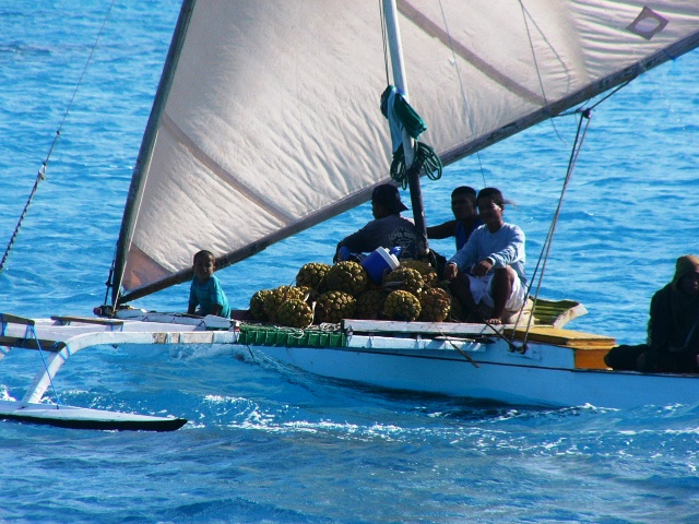 An Ailuk family transports pandanus fruit by canoe. Photo: Arc Tracer