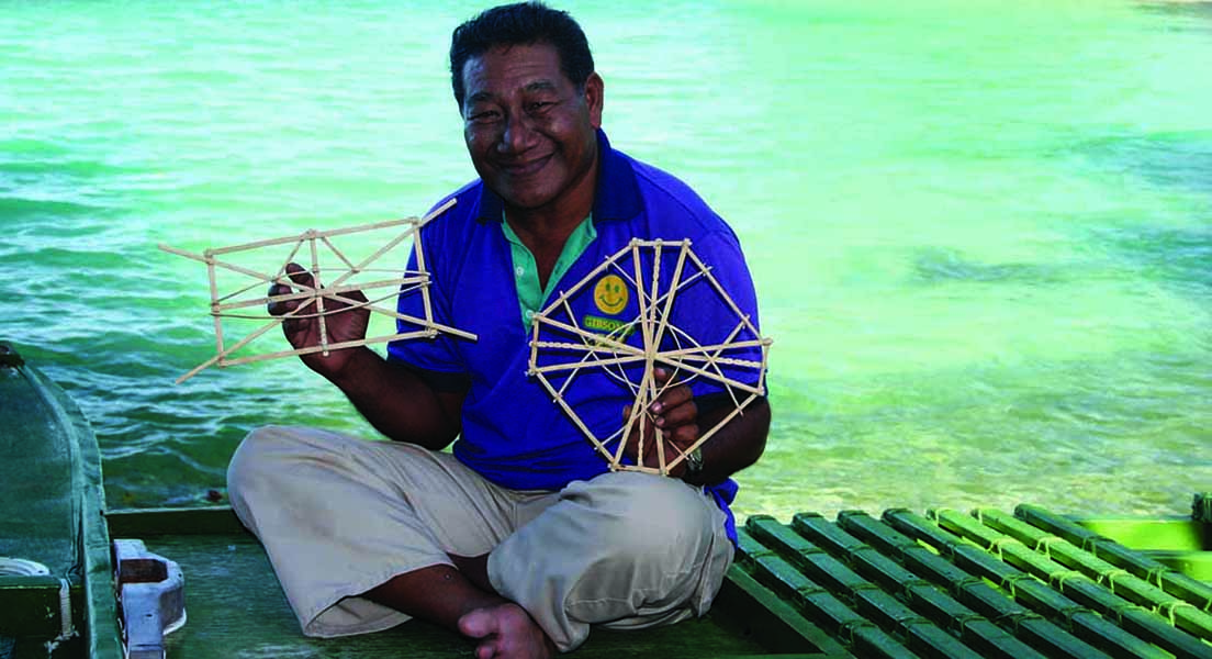 Master navigator Captain Joel Korent holds stick charts, which are key to training of novice navigators.