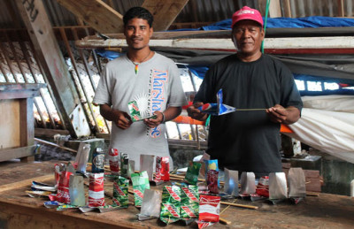 WAM's Linton Baso and Binton Daniel work on the yacht club beer can boats. Photo: Laura Masterson.