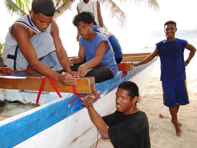 Young men of Ailuk work on the refit of the canoe in 2013.